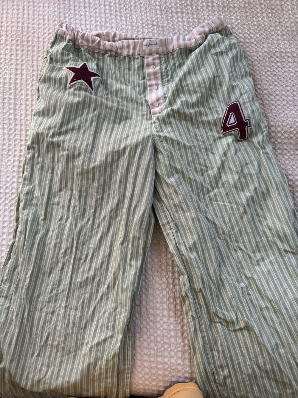 Out from under green and white striped boxer sleep pants